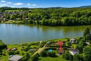 an aerial view of a house next to a lake at Modrobílá chatka u rybníka in Holoubkov