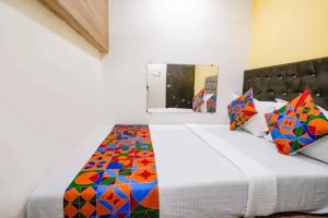 a bedroom with a large bed with colorful pillows at Via Palace Residence in Mumbai
