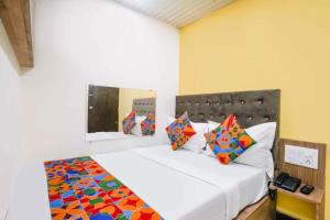 a bedroom with a large white bed with colorful pillows at Via Palace Residence in Mumbai