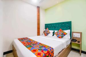 a bedroom with a large bed with a colorful comforter at Via Palace Residence in Mumbai +28 photos