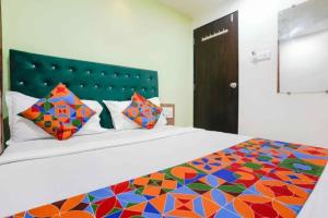 a bedroom with a large bed with a colorful comforter at Via Palace Residence in Mumbai