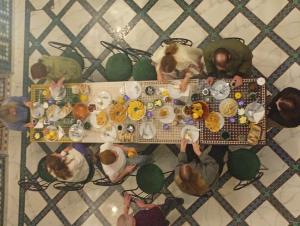 a group of people sitting around a table with food at Riad la Fíbula de Nora in Fez