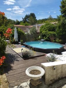 a swimming pool sitting on a wooden deck with a toilet at Iglesias Emmanuelle in Pradines