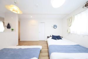 two beds in a room with white walls at 天空山 in Kawagoe