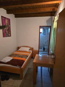 a bedroom with a bed and a table and a mirror at Vila PAUN in Doboj
