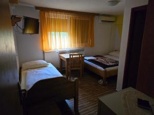 a small room with two beds and a table at Vila PAUN in Doboj