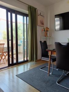 a living room with a television and a table and chairs at Apartments Marica in Trogir