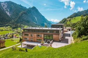 a house on a hill with mountains in the background at Haus Gaues in Dalaas