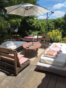 a patio with a table and chairs and an umbrella at Iglesias Emmanuelle in Pradines