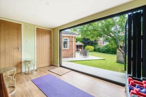an open living room with a large sliding glass door at The Garden Studio in Wargrave