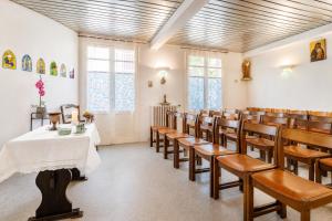 a room with a table and chairs in a church at Hôtel Compostelle in Lourdes