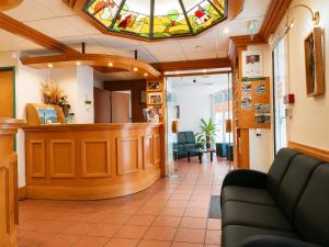 a waiting room with a stained glass window and a bar at Hôtel Compostelle in Lourdes