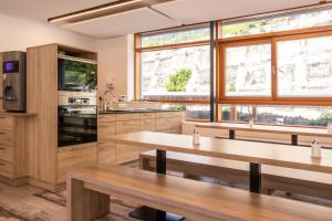a kitchen with wooden tables and windows at Haus Gaues in Dalaas
