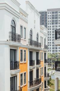 an apartment building with balconies in front of buildings at Lavena Boutique Hotel in Sầm Sơn
