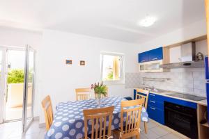 a kitchen and dining room with a table and chairs at Apartments Silvia in Novalja +29 photos