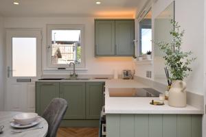 a kitchen with green cabinets and a table at Kilbride Lodge in Carrick