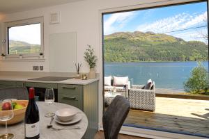 a kitchen with a table and a view of a lake at Kilbride Lodge in Carrick