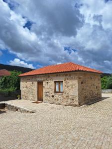 a small stone building with an orange roof at Villa Barbosa in Quintiães
