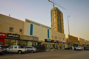 a street with cars parked in front of a building at Nawara Dala - Economic in Riyadh
