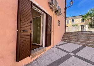 a door to a building with stairs in a courtyard at Isuleddu Room & Stairs in La Maddalena +15 photos