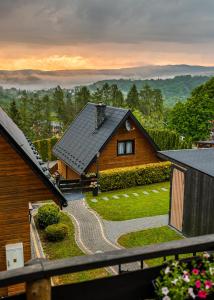 a house with a view of a yard at Domki nad Zaporą w centrum Soliny przy Zaporze - wybrane domki z jacuzzi in Solina