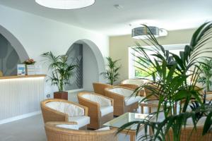 a waiting room with chairs and plants at Hotel Giardino La Playa - Adults Only in Alghero