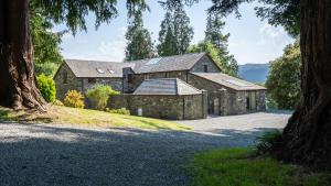 an old stone house with solar panels on the roof at Plas Madoc Coach House in Conwy