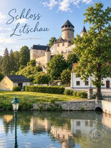 a castle on top of a hill next to a river at Hauszeit mit Pfoten in Litschau