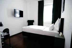 a hotel room with a bed and a window at Hotel NeuHaus in Dortmund +26 photos