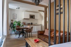a living room with a couch and a table at La Maison du Corsaire et Les Ateliers - deux adresses à Honfleur in Honfleur