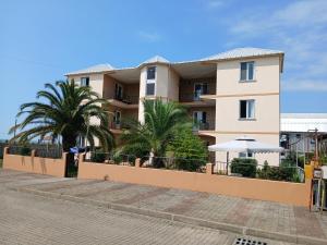 a building with palm trees in front of it at Nika Inn Kobuleti in Kobuleti