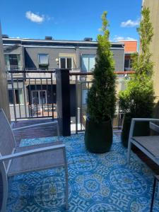 a patio with two benches and trees on a balcony at SV Appartamenty in Horten