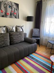 a living room with a couch and a colorful rug at SV Appartamenty in Horten