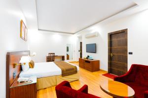 a hotel room with a bed and two chairs at Span inn & Suites by Alivaa, Manali in Baragrān +37 photos