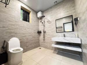 a bathroom with a toilet and a sink and a mirror at Cactus Hotel in Dar es Salaam +56 photos