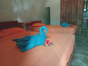 a room with two beds with a swan on them at Fortunate Lodge, Restaurant & Bar in Lénakel