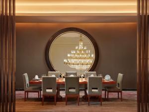 a dining room with a table and a large mirror at Mövenpick Hotel Hanoi Centre in Hanoi +154 photos