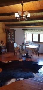 a living room with a table and chairs at Casuta lui Andrei in Brezoi