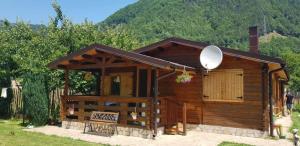 a small wooden cabin with a satellite at Casuta lui Andrei in Brezoi