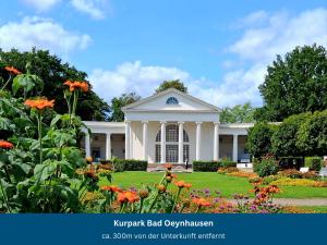 a white house with flowers in front of it at Bad Oeynhausen - City, Küche, Netflix, Wifi, zentral, StudioApartment in Bad Oeynhausen +6 photos