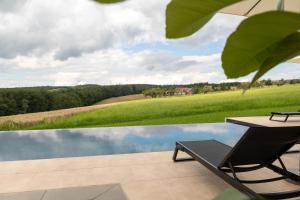 a patio with a table and a chair next to a pool at Schwarzwald Chalet Auwald in Freiamt