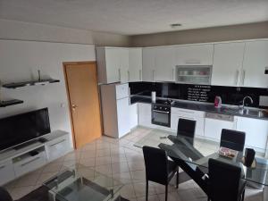 a kitchen with a glass table with chairs and appliances at Apartman Pecara in Široki Brijeg