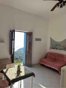 a room with a bed and a table and a window at Melania Home in Filicudi