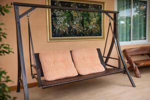 a swing in a room with two orange pillows at Lay de Bua Resort in Phatthalung