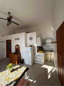 a kitchen with a white refrigerator and a table at Melania Home in Filicudi