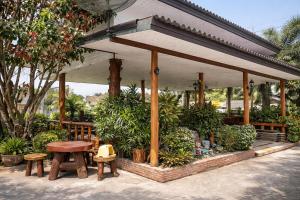 a pavilion with a table and benches and plants at Lay de Bua Resort in Phatthalung