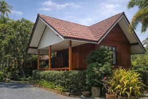 a small wooden house with a brown roof at Lay de Bua Resort in Phatthalung