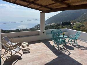 a patio with chairs and a table on a balcony at Melania Home in Filicudi