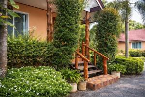 a wooden stairway leading to a house with plants at Lay de Bua Resort in Phatthalung +16 photos