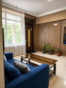 a living room with two blue couches and a coffee table at All residence in Almaty